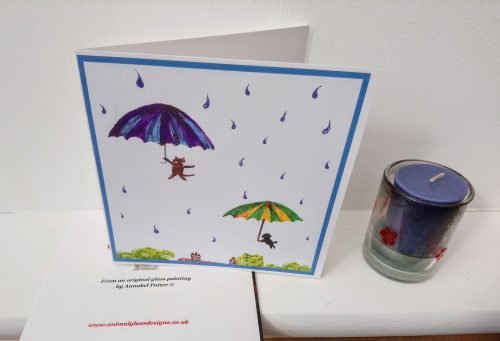 Funny card with a cat and dog in the sky with umbrellas and raindrops around them.